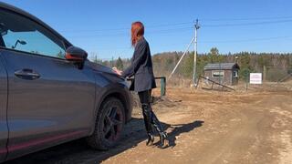 The girl in high-heeled boots realized that she couldn't drive through the mud field and would have to walk through the mud