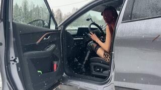 A girl is stuck in the terrible cold, driving a car on a bad road, she is in very light clothes waiting for help on the street and is trembling violently