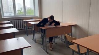 A girl is sitting in class and preparing her topic, a classmate is imperceptibly filming her feet and ballet flats on camera (reissue)