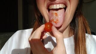 Lania eats and smashes cherry tomato with her mouth
