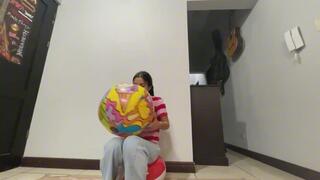 Akina blows a small beach ball