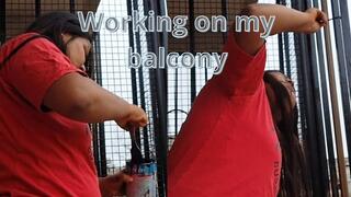 Indian woman painting on her balcony