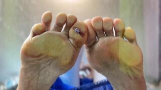 A shrinking guy under the soles of a giantess' feet