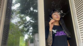 smoking absent-mindedly at the window