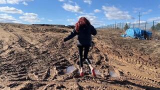 A girl in very high heels with a platform walks through very deep and sticky mud (reissue)