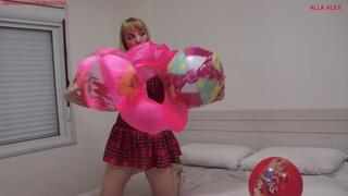 Alla inflates three beach balls and an inflatable ring with her mouth