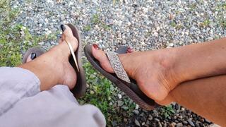 2 women let their sandals dangle while tapping them with the tips of their toes (1)