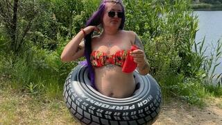 Girl on beach blowing big balloon with nailpop