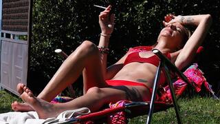 Eve sensually smoking 120's cigarette while sunbathing in slow motion 2
