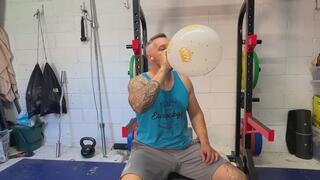 Sweaty JL after a workout blowing up and squeezing to pop some big balloons