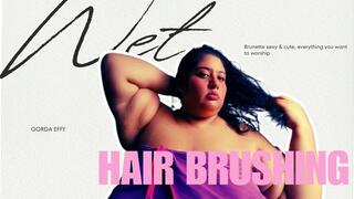 A scantily clad brunette brushing her hair
