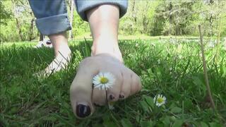 Christine tramples, rubs and pull-off grass and flowers barefoot