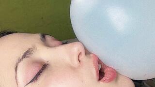 Pretty girl rubs herself with balloons and pops them