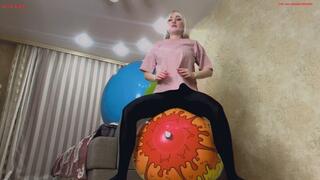Alla does fitness with two large beach balls and happily jumps on them