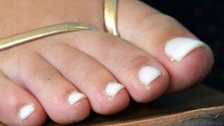 Foot and sandals fetish admiration series, feet close-up, dirty toes and white polish nails