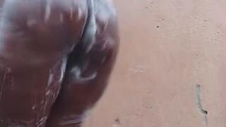 Beautiful African girl bathing outdoors