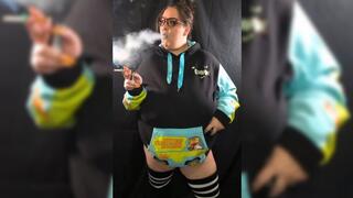 Smoking in hoodie with big exhales