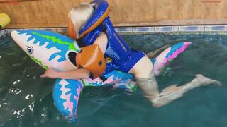 Alla hotly rubs herself astride a rare inflatable shark in a pool and wears a rare inflatable Snorkel Pro vest