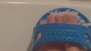 Scrubbed feet clean in the bathtub.