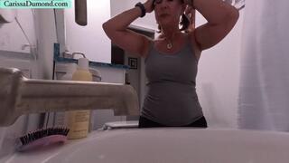 Carissa washes and conditions her hair while topless and kneeling at the tub