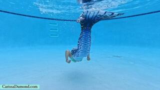 Carissa in the mermaid tail swimming and blowing bubbles in the pool
