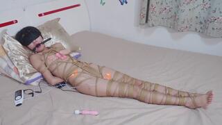 The almost naked girl was tied up with numerous ropes; her genitals were stimulated, and she reached orgasm as a result.