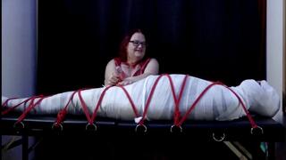 Miss M torments a helpless mummified man for Halloween