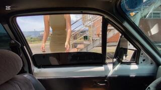 Anie, wearing a short dress, drives an old Chevette that breaks down a lot.