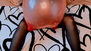 Empress Scarlett blows to pop a 30” mouse balloon