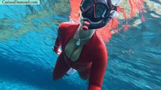 Carissa snorkeling in the dark part of the spring in her shiny red catsuit
