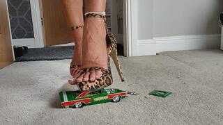 Nikkichick crushes a 1968 Dodge Dart in leopard high heels with painted toe nails toy car crush close ground view