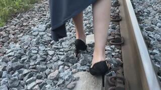 A girl in high-heeled shoes is walking, she is distracted by the call and does not look at all where she is stepping