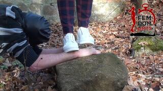 Hard crushing hands in sneakers on cold stone