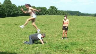 2 Girls Jumping On Their Slave In A Field Whilst On All 4's