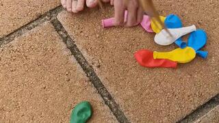 Carina playing with ballons and a compressor to burst them.