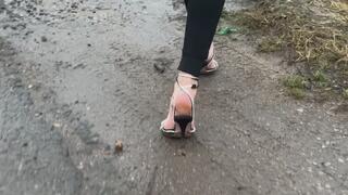 A girl in shiny new shoes walks in the mud in bad weather