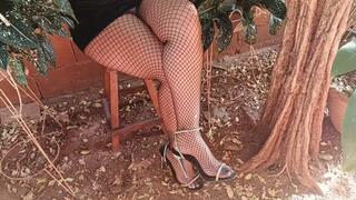 With fishnet stockings and high heels on her feet, woman crosses her legs (3)