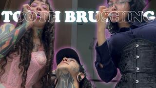 Two giantesses brush their teeth and spit out the small human