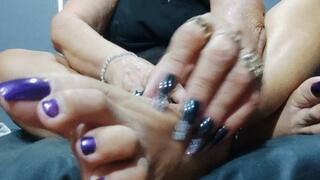 Woman with big nails on her hands scratching her feet (1)