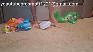 Nastya tramples inflatable toys with her bare feet, crushes them with her weight, destroys them