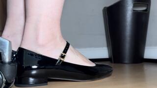 Close up Shoeplay under the desk in patent black flats