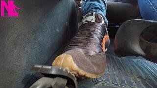 Driving and pedal pumping in brown Nike speakers and blue jeans