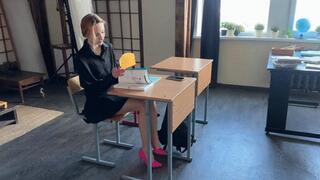 A schoolgirl does homework in class and plays with shoes, sometimes she loses her shoes under the desk