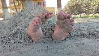 Mature woman buried in beach sand leaving only her wrinkled soles outside (1)