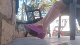Some beautiful flip flops hanging and hitting the heel when pushed (c1)