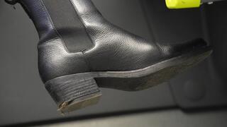 Bratty woman with dirty riding boot close-up. Boot fetish admiration and inspection.