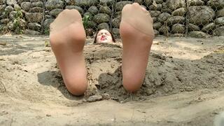 Ticking her feet with pantyhose while she is buried in beach sand (2)