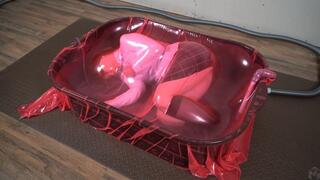Sonya in a cement basin inside a pink vacuum cocoon