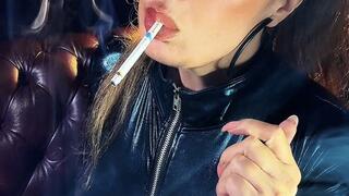 Filling her lungs, wearing a catsuit, ponytail, eyes lined in black, and Lipgloss - Dunhill Menthol 100