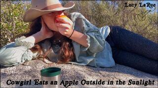 Cowgirl Eats an Apple Outside in the Sunlight